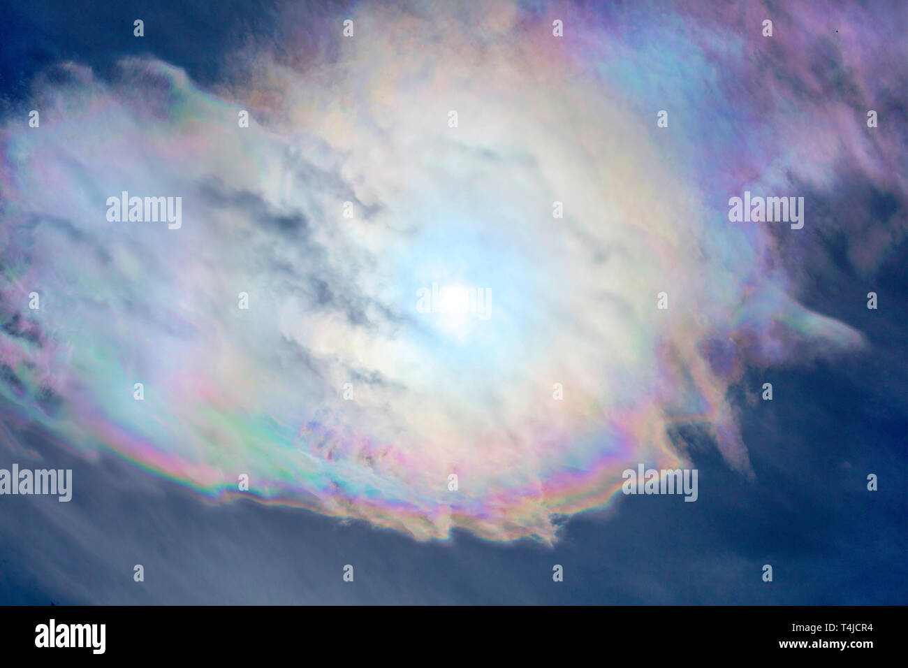 Cloud iridescence is an optical phenomenon creating colorful pastel bands. Stock Photo