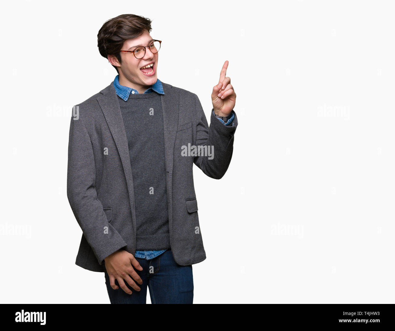 Young handsome business man wearing glasses over isolated background with a big smile on face, pointing with hand and finger to the side looking at th Stock Photo