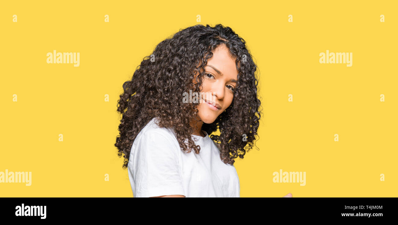 Young Beautiful Woman With Curly Hair Wearing White T Shirt
