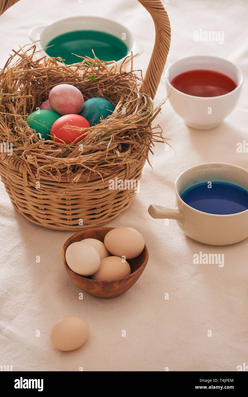 Beautiful Easter composition with multicolored eggs and flowers on linen background Stock Photo