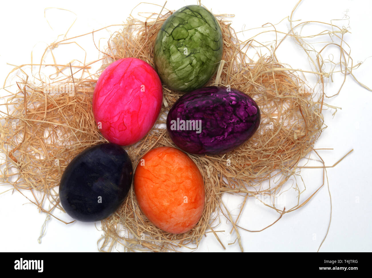 Colourfully painted Easter eggs with straw Stock Photo