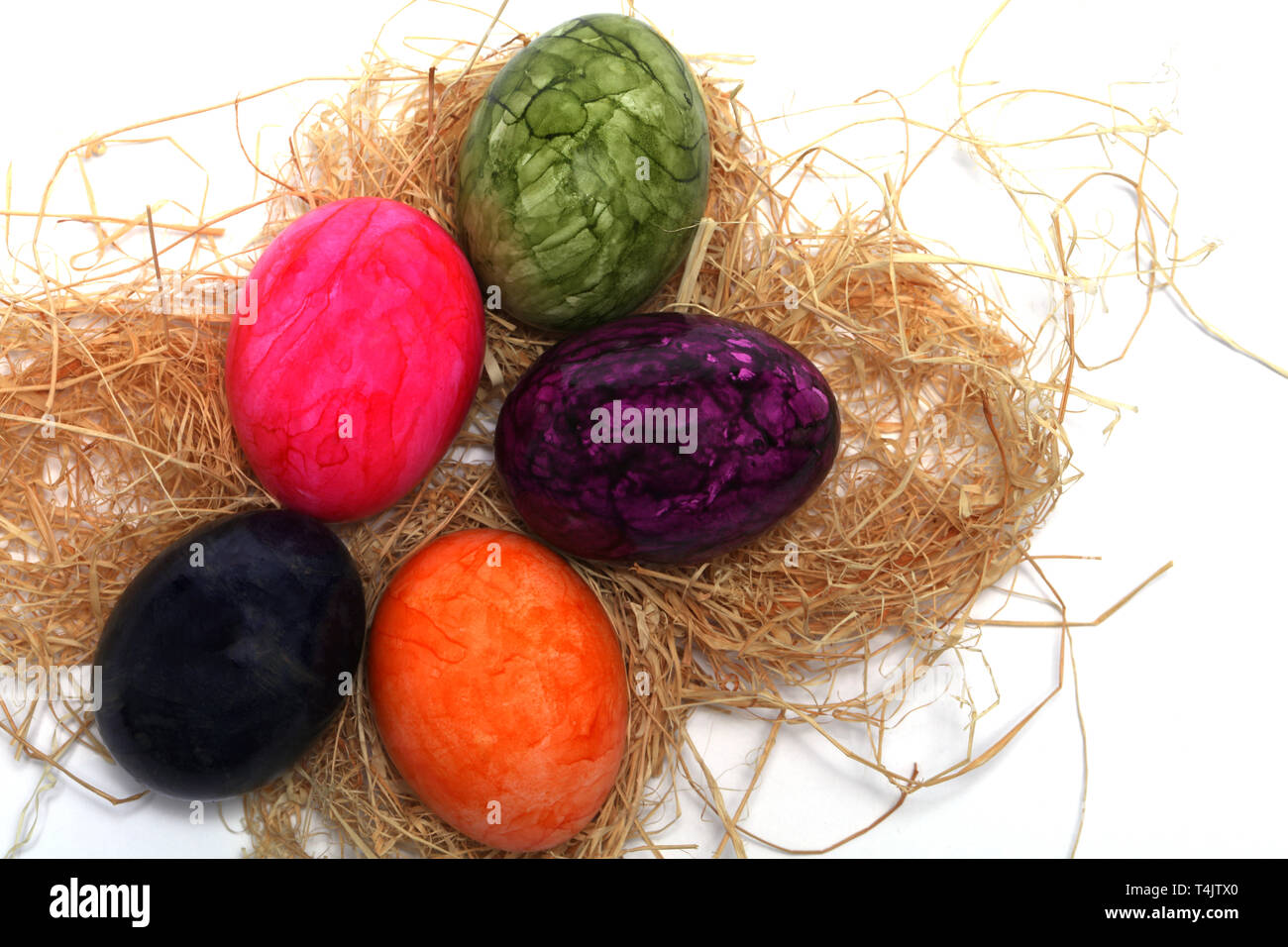 Colourfully painted Easter eggs with straw Stock Photo