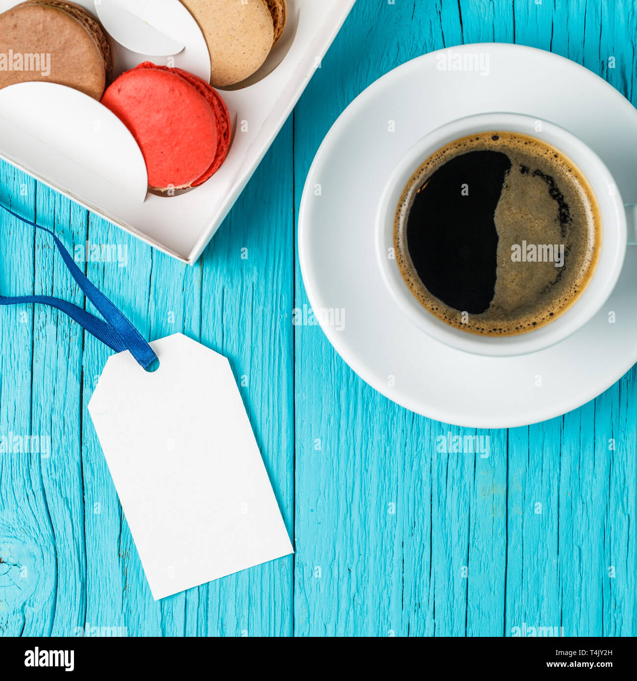 Multicolored macaroons, empty postcard, coffee Stock Photo