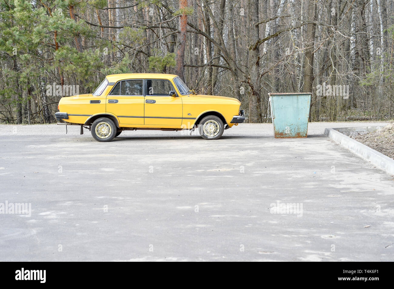 Old yellow car brand Moskvich AZLK 2140 parked near the garbage can in the Parking lot of the sanatorium Miner Russia, Kursk region, Zheleznogorsk, Ap Stock Photo