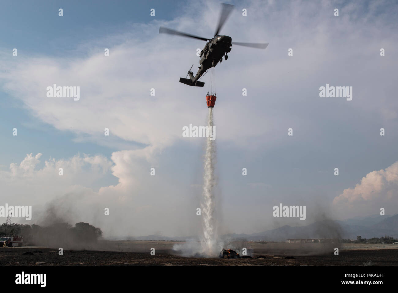A UH-60 Blackhawk from the 1-228th Aviation Regiment aims to extinguish a simulated wildfire to show the additional capabilities of Joint Task Force - Bravo during the Central America Sharing Mutual Operational Knowledge and Experiences (CENTAM SMOKE) exercise, April 11, 2019, at Soto Cano Air Base, Honduras. CENTAM SMOKE brought together firefighters from Honduras, Costa Rica, Belize, Guatemala and El Salvador to train with U.S. Air Force members as well as develop bonds and understandings of one another’s culture with team building exercises. The weeklong training included aircraft and struc Stock Photo