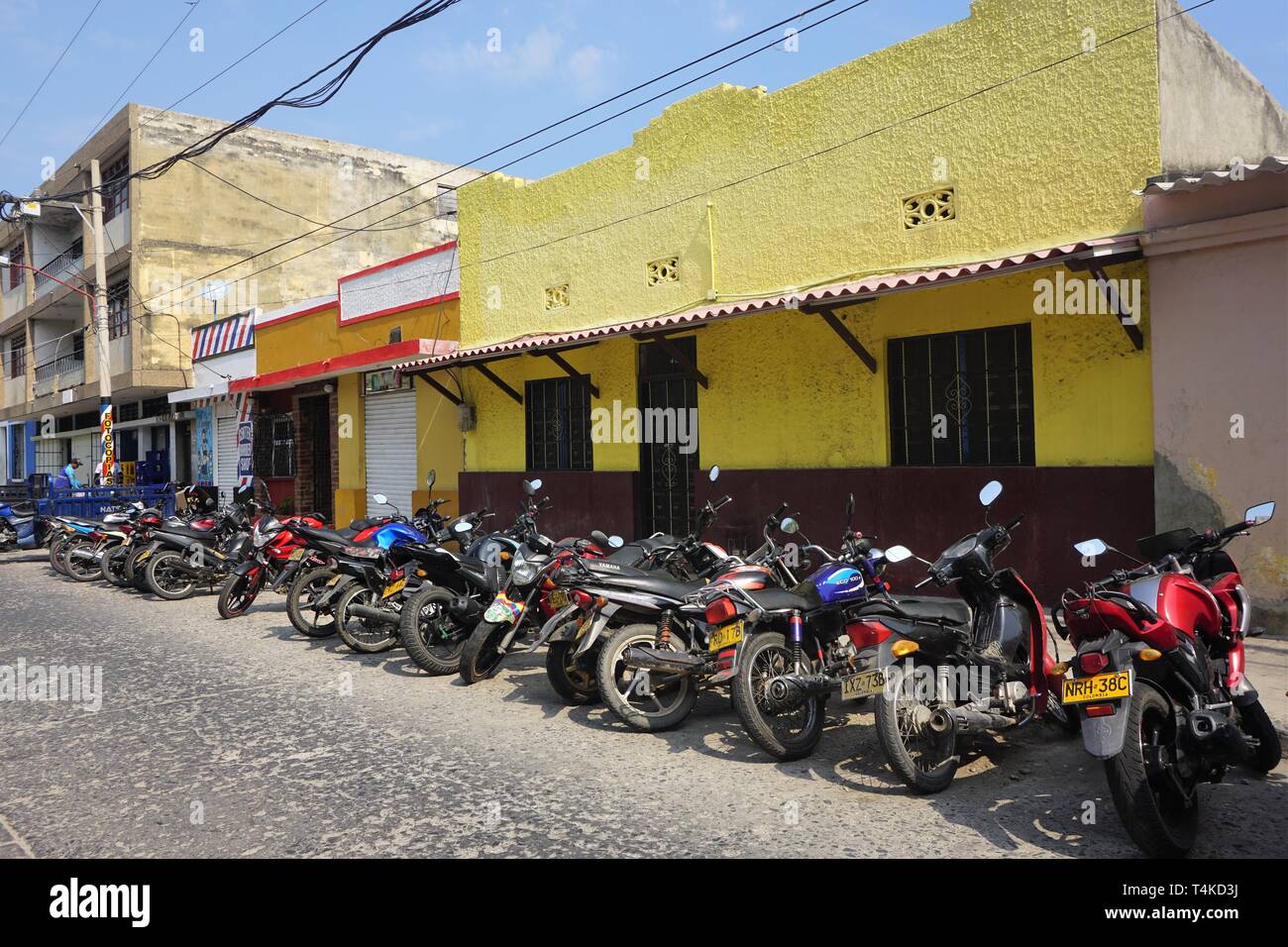 Diminishing View of a Row of Motorcycles parked in a sunlit Street Stock Photo