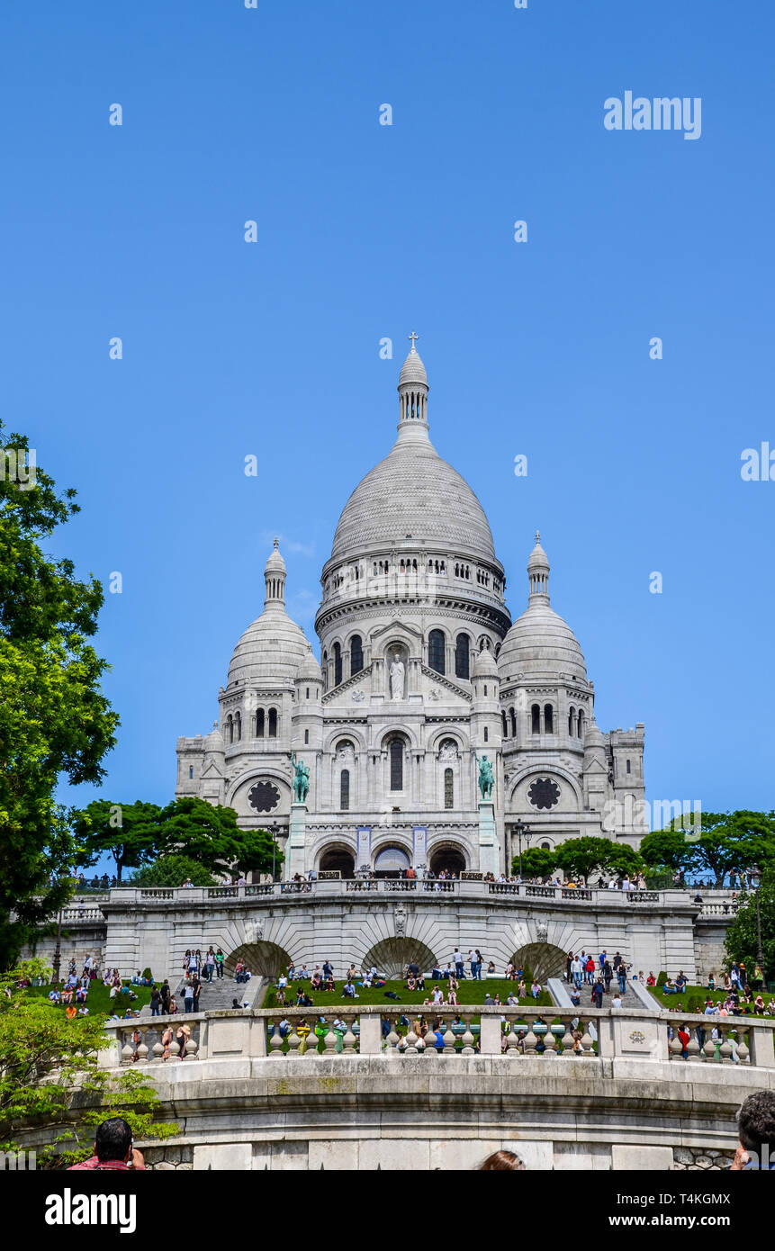 Basilica of the Sacred Heart of Paris, commonly known as Sacré-Cœur Basilica and often simply Sacré-Cœur, Paris, France, with visitors. People Stock Photo
