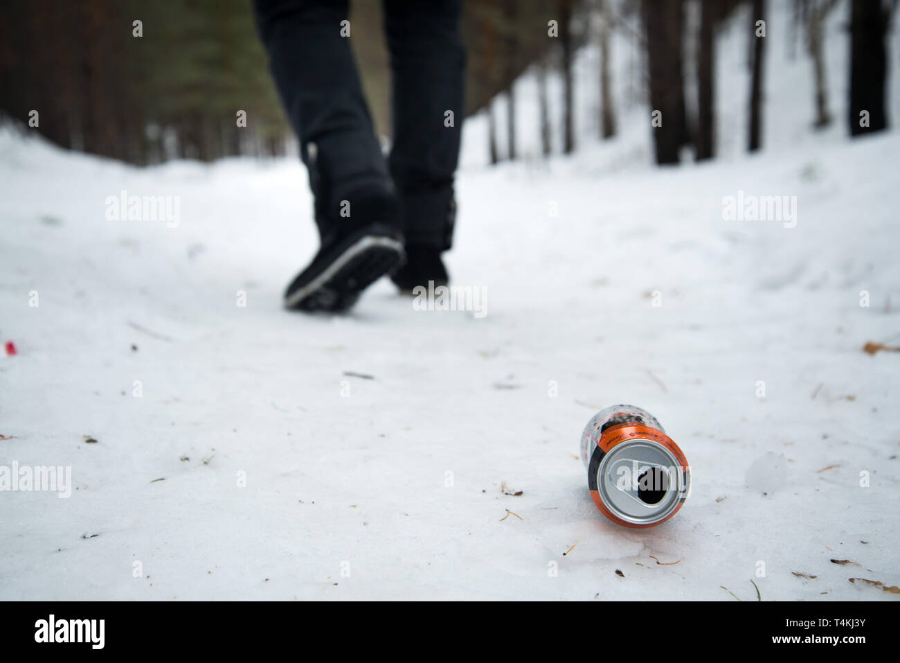thrown beer can on the snow in the park , outgoing person Stock Photo