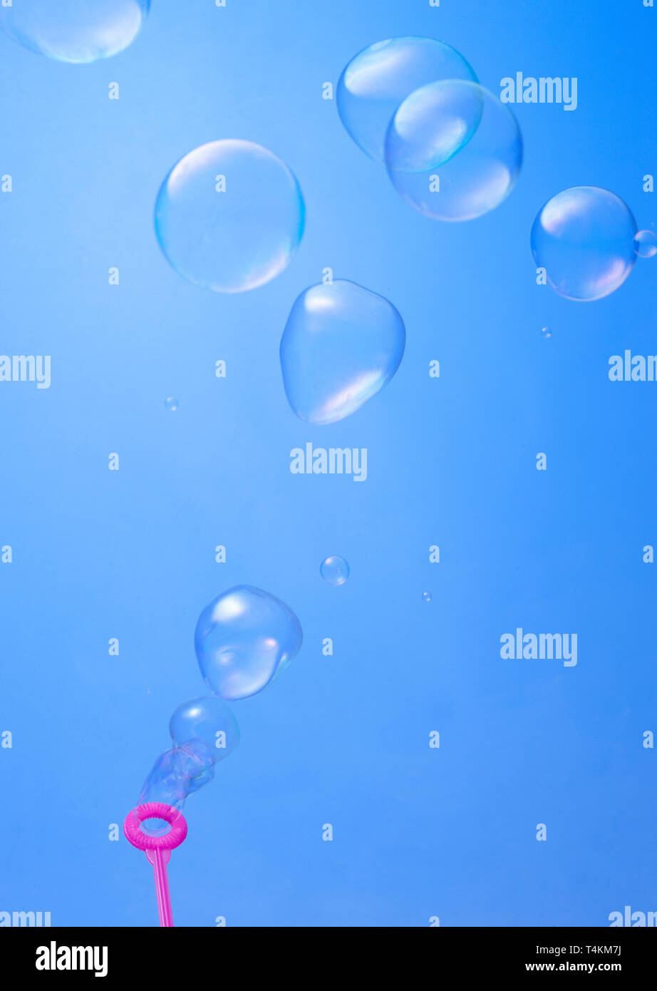 blowing soup bubbles on blue background Stock Photo