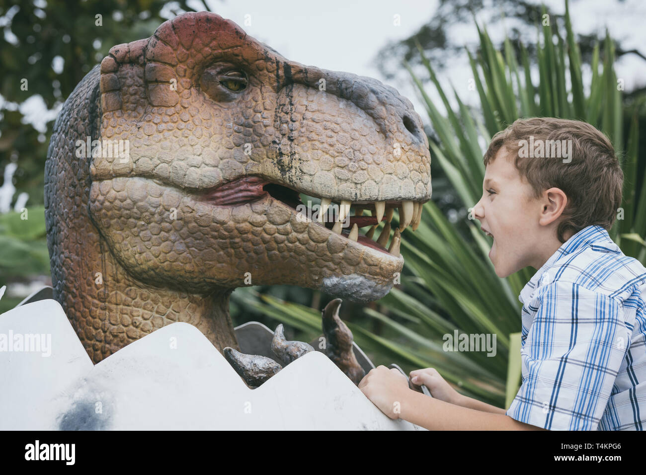 little boy playing in the adventure dino park. Concept of happy childhood. Stock Photo