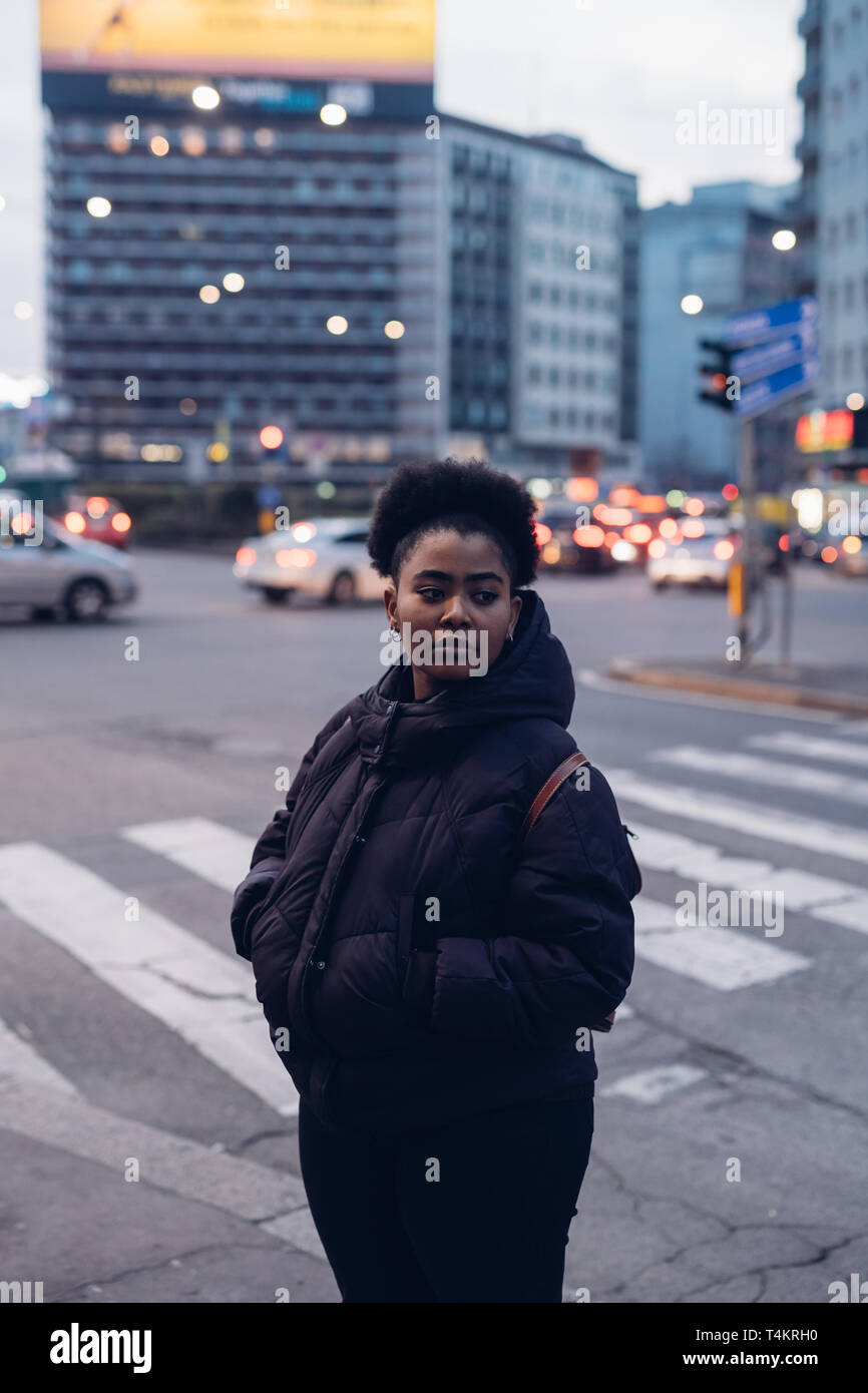 young black and curly girl posing in the street looking ahead - metropolitan, expressive, searching. Stock Photo