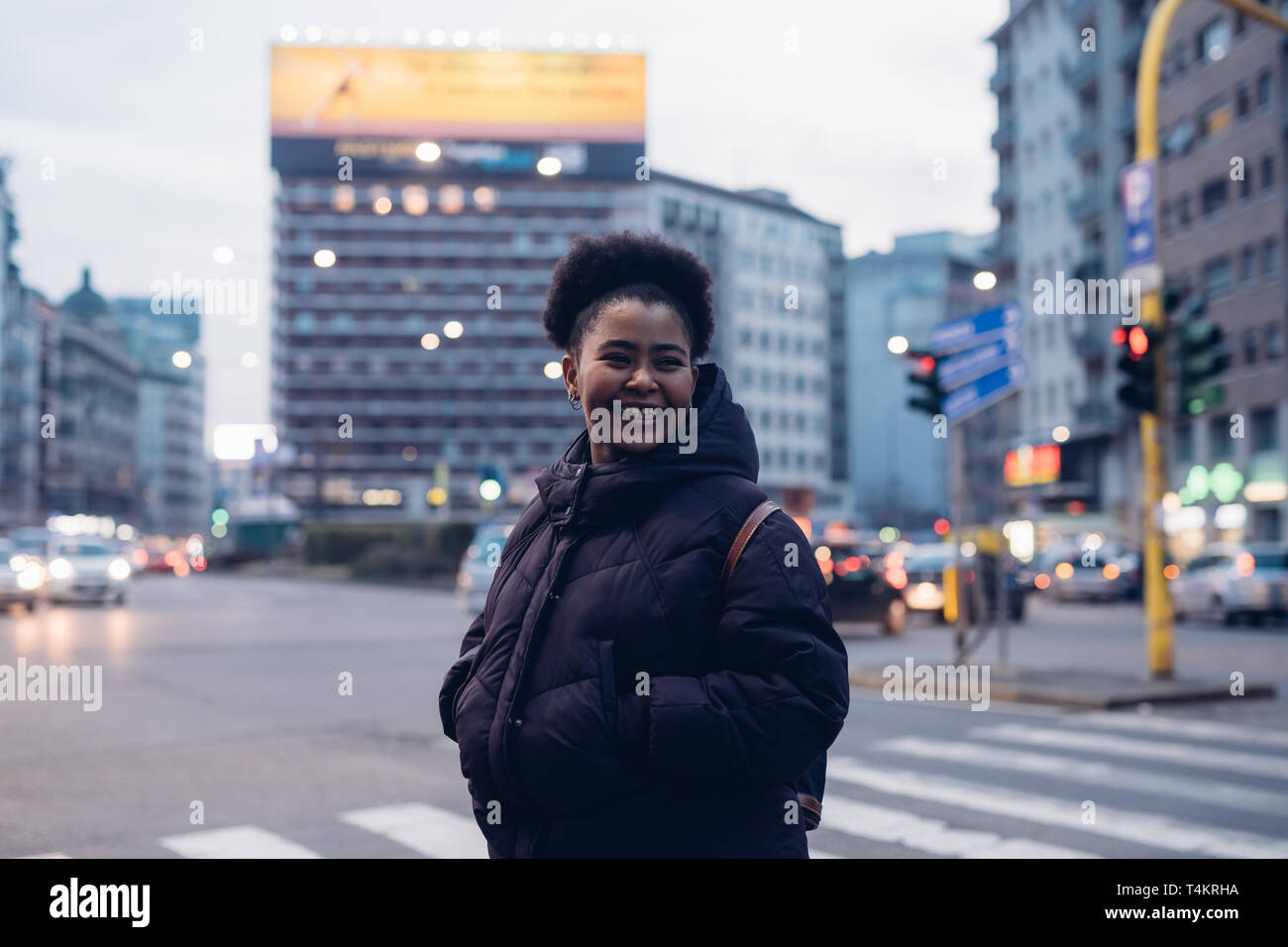 african and curly girl smiling in the street- metropolitan, expressive, charming Stock Photo