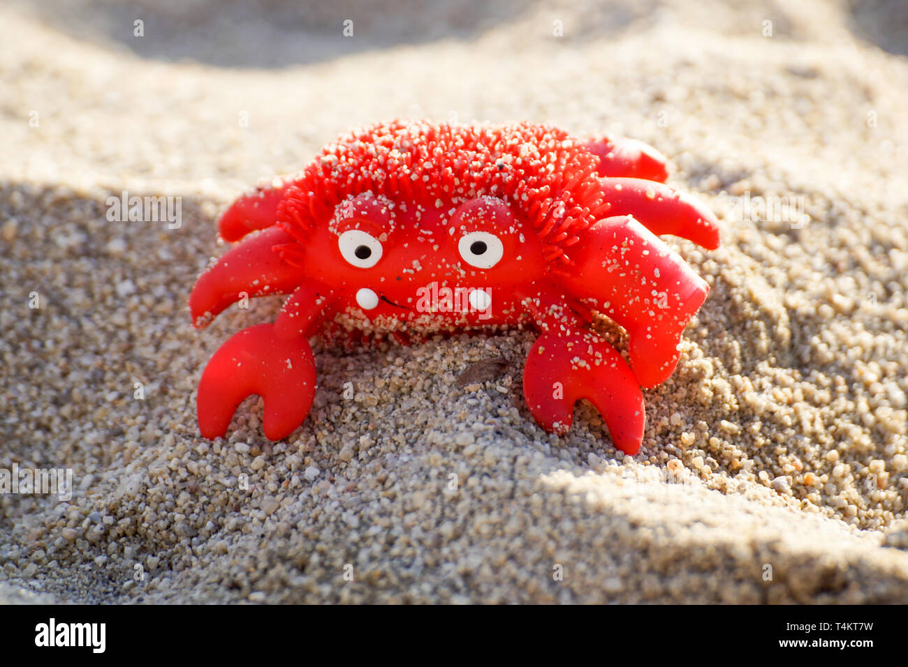 Colourful red crab toy on a beach Stock Photo