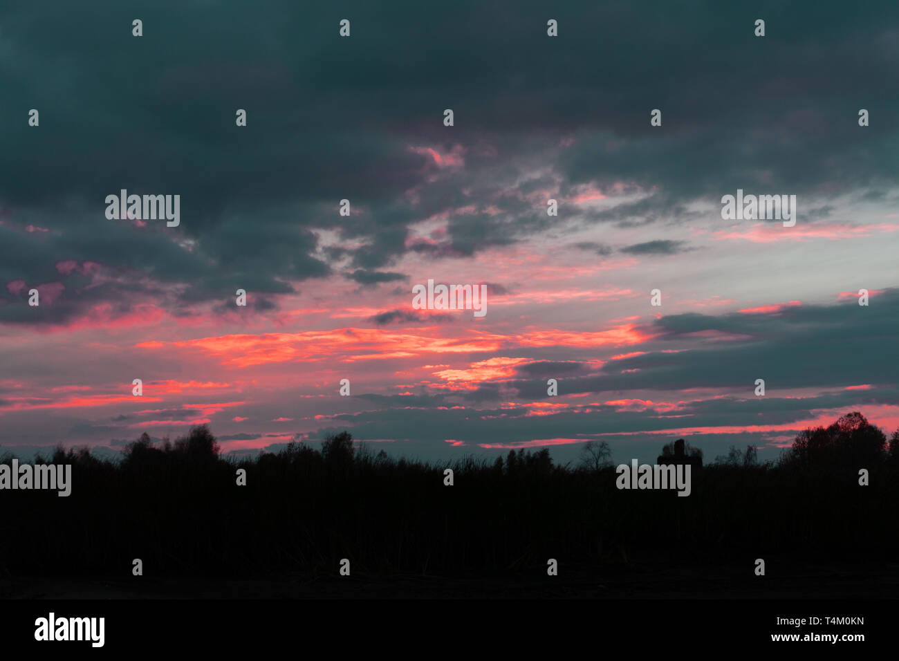 The setting sun silhouettes hills as it reflects upon the waters of the