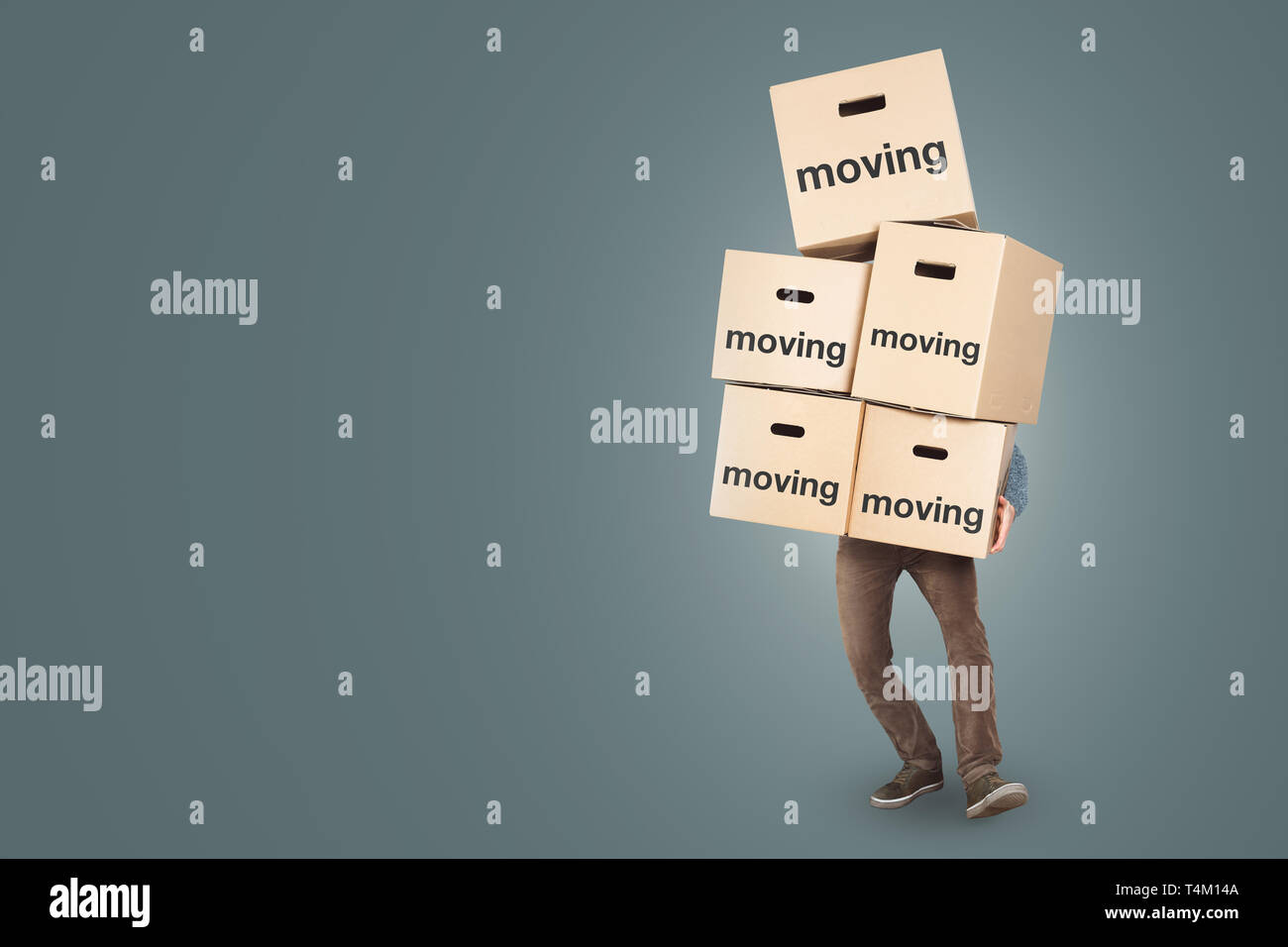 A man is carrying many moving boxes - isolated on a neutral background with copy space Stock Photo