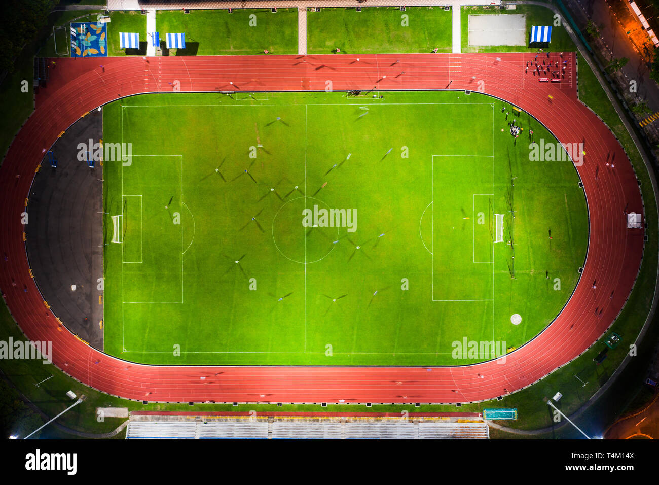 Aerial view of a soccer pitch with players playing soccer and a running