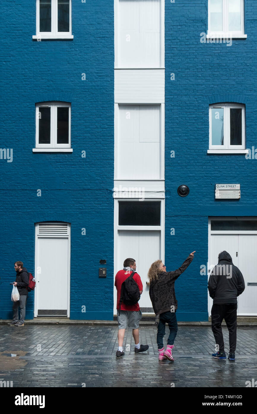 People standing in front of a building painted in blue and white in Clink Street in London. Stock Photo