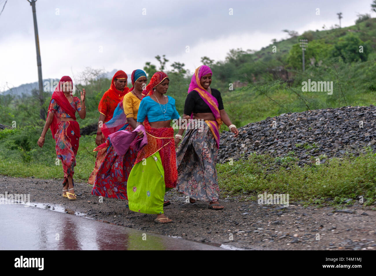 Group of rajasthani women with colourful dress walking along a road in Rajasthan, India Stock Photo
