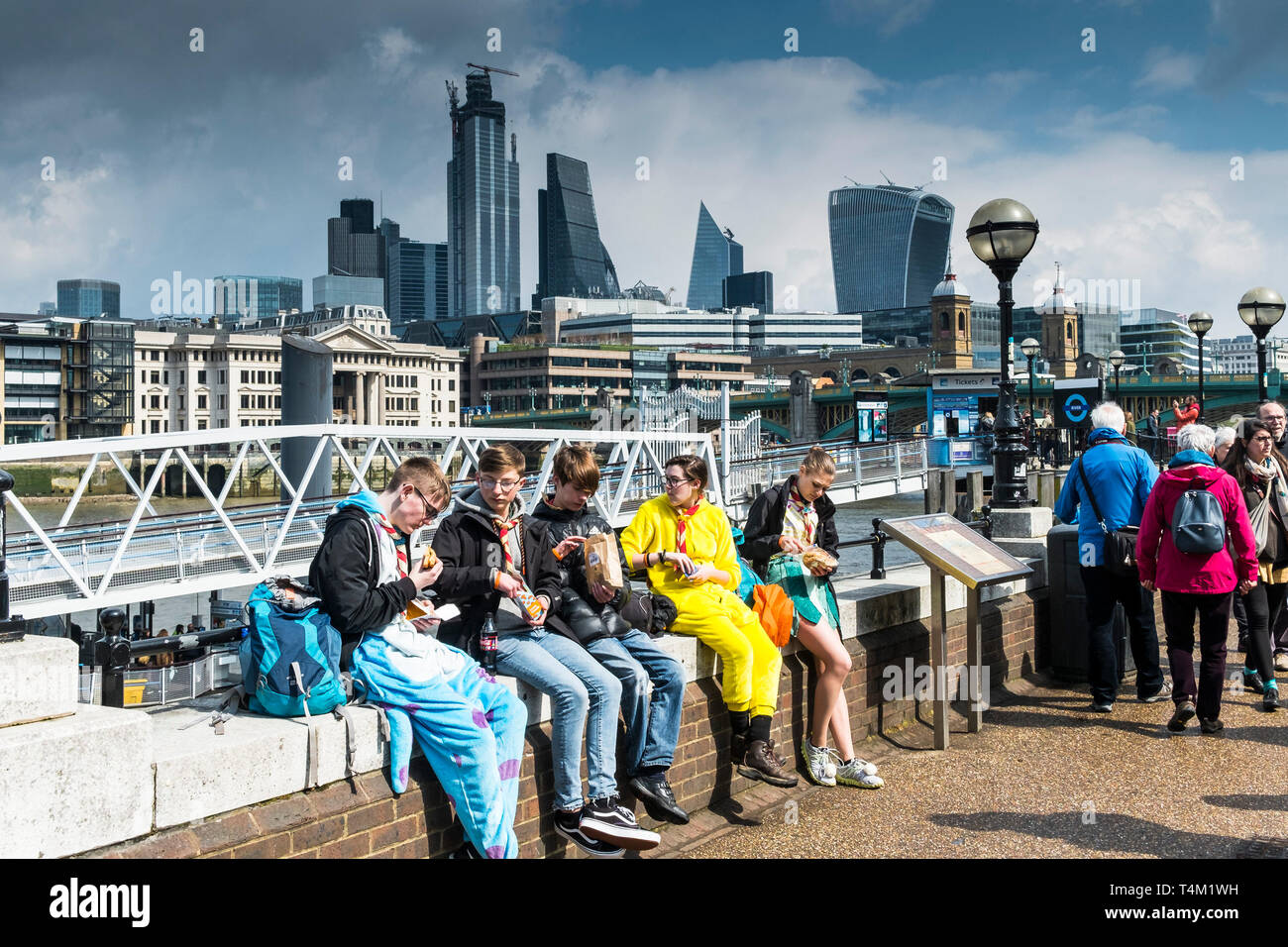 A group of Scouts eating food on the South Bank in London. Stock Photo
