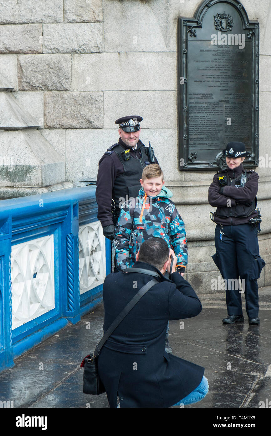 A father taking a photograph of his young son and two Metropolitan Police officers in London. Stock Photo