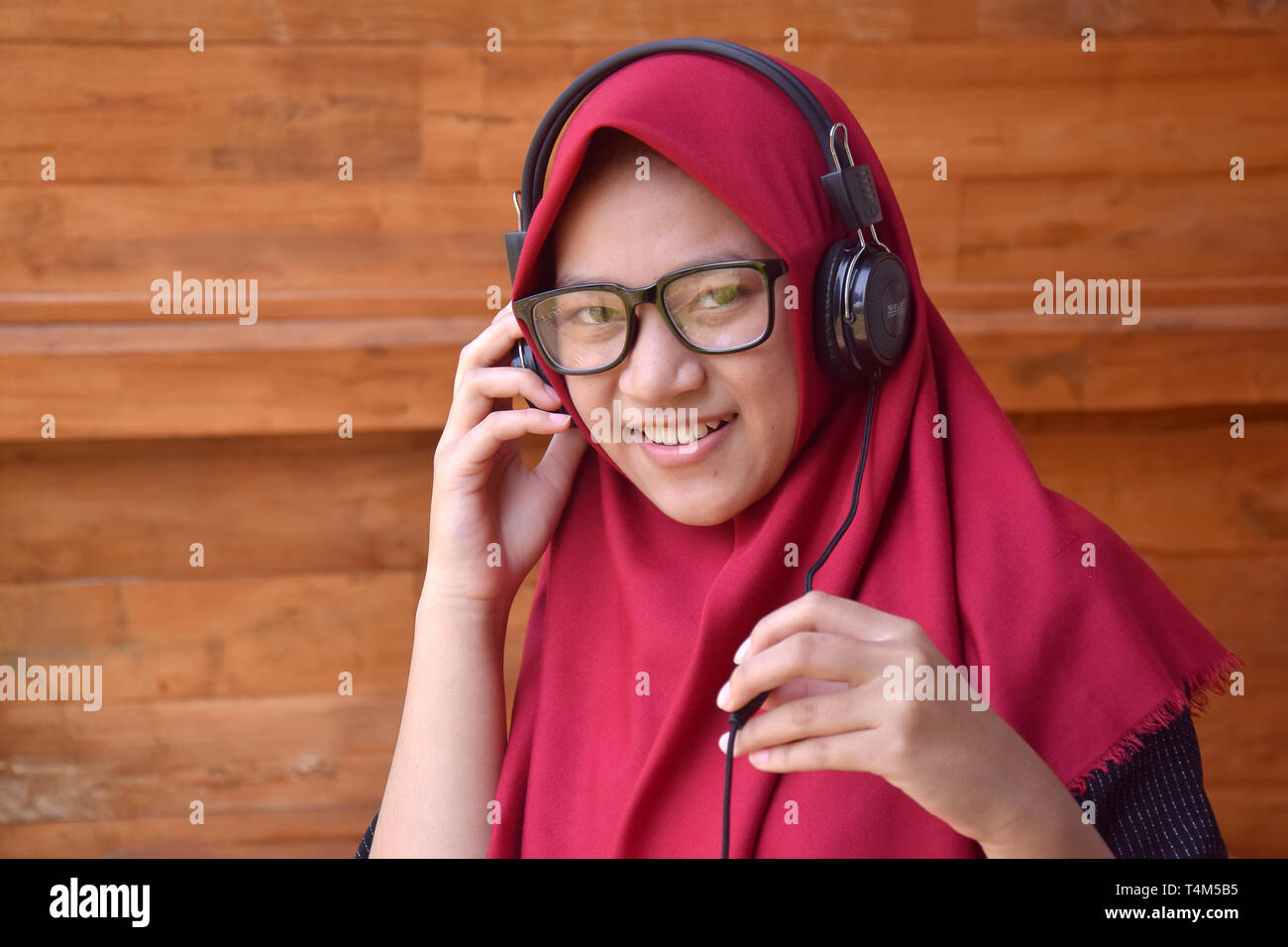 Asian Muslim teenagers, with a smile using Mobilephone to listen to music and selfies to take pictures of them Stock Photo