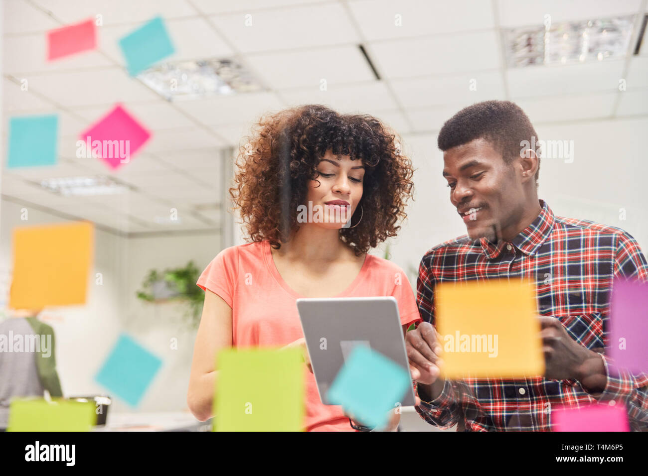 Two young freelancers as software developer team with tablet computer in start-up office Stock Photo