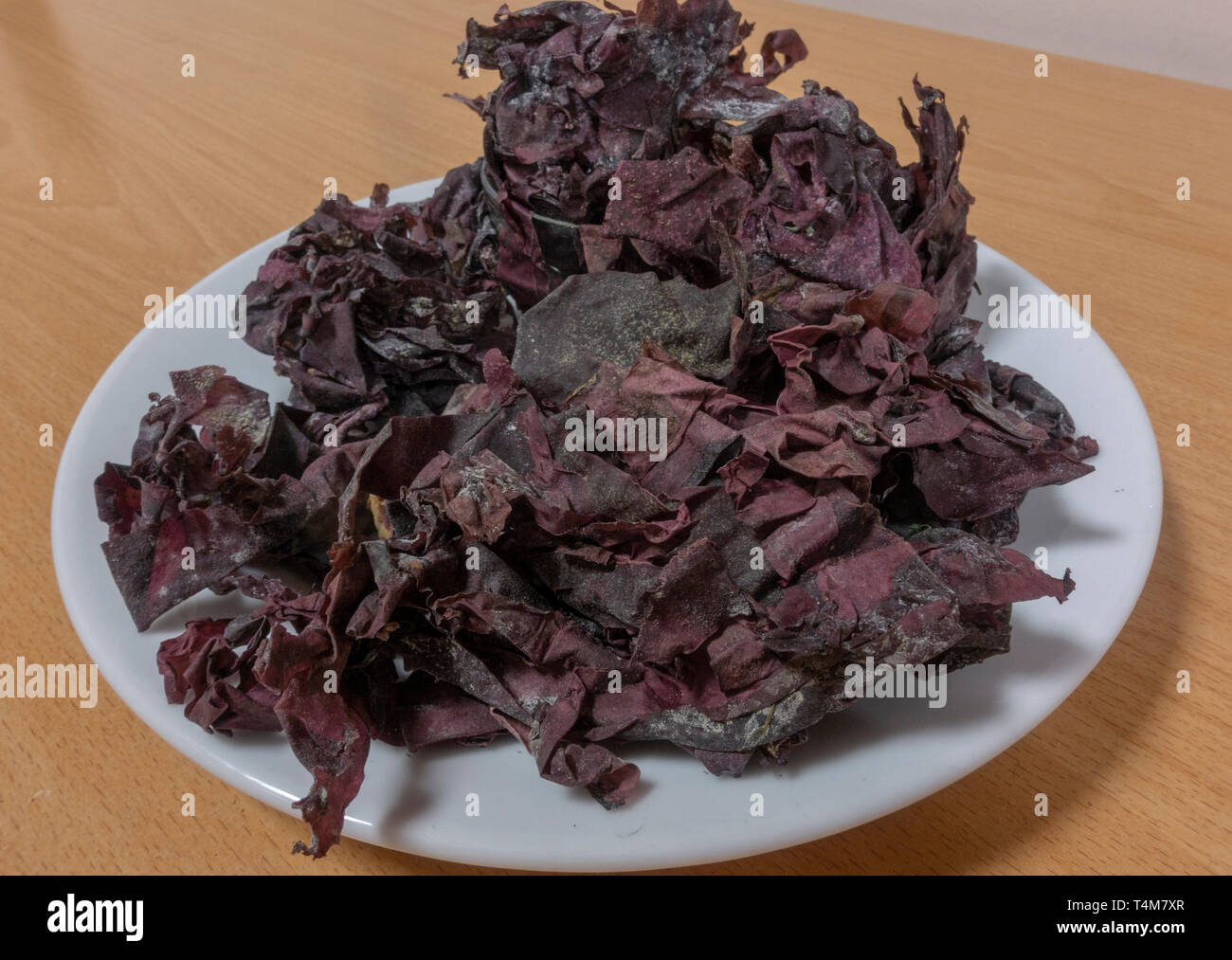 Palmaria palmata, also called dulse, dillisk or dilsk, red dulse, sea lettuce flakes, or creathnach on a plate. Stock Photo