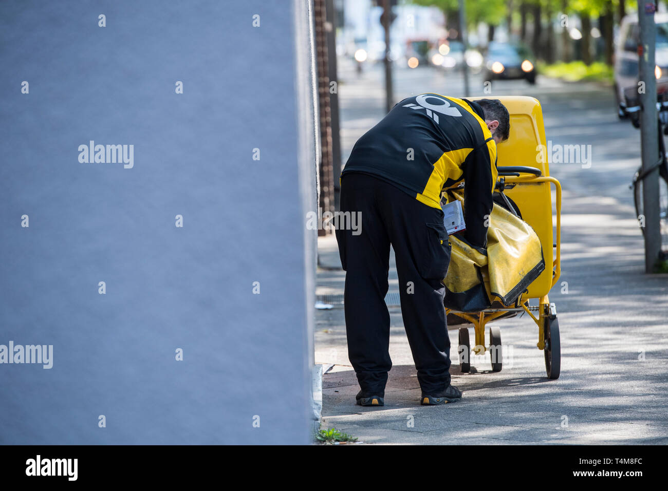 Postbote in der Großstadt zu Fuss unterwegs. Stock Photo