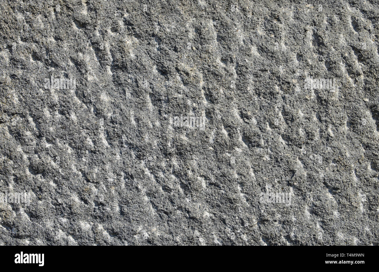 Ancient grey stone block with rough surface as background Stock Photo