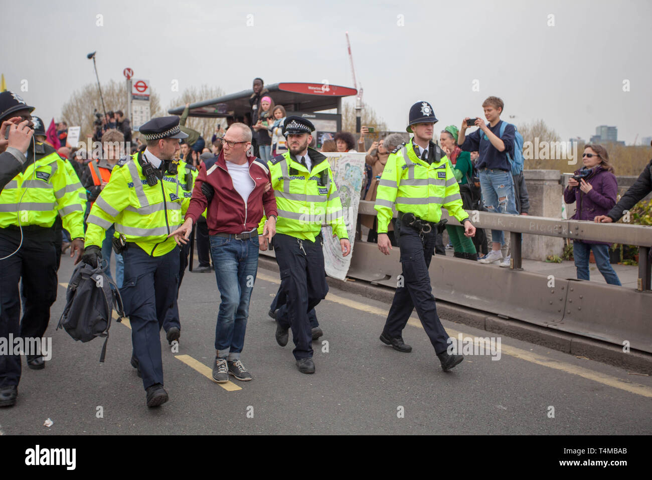 16th April 2019: Excitation Rebellion: Protester getting lead away in handcuffs by a Met Police Officer on Waterloo Bridge, London.UK Stock Photo