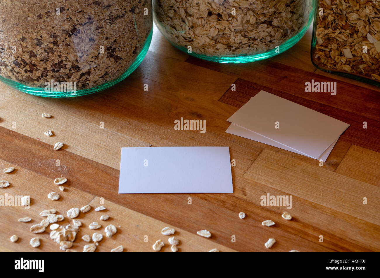 business card mockup templates on a table with sprinkled oatmeal - muesli jars in background Stock Photo