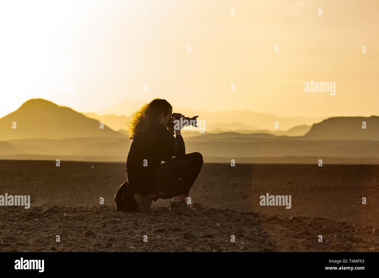 A photographer taking a picture of the sunset in the Wadi el gamal desert, Egypt. Stock Photo