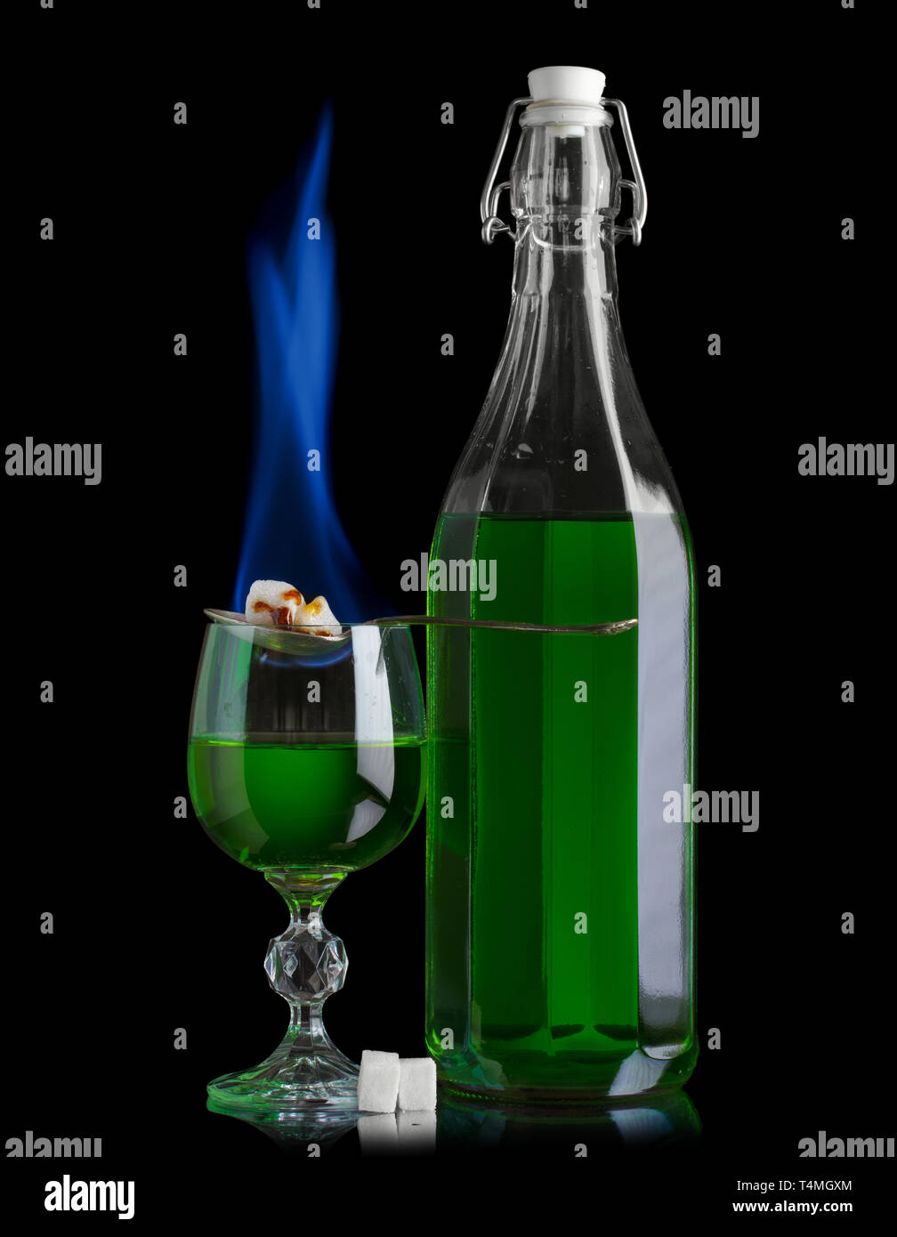 Absinthe bottle and glass with lump sugar burning Stock Photo
