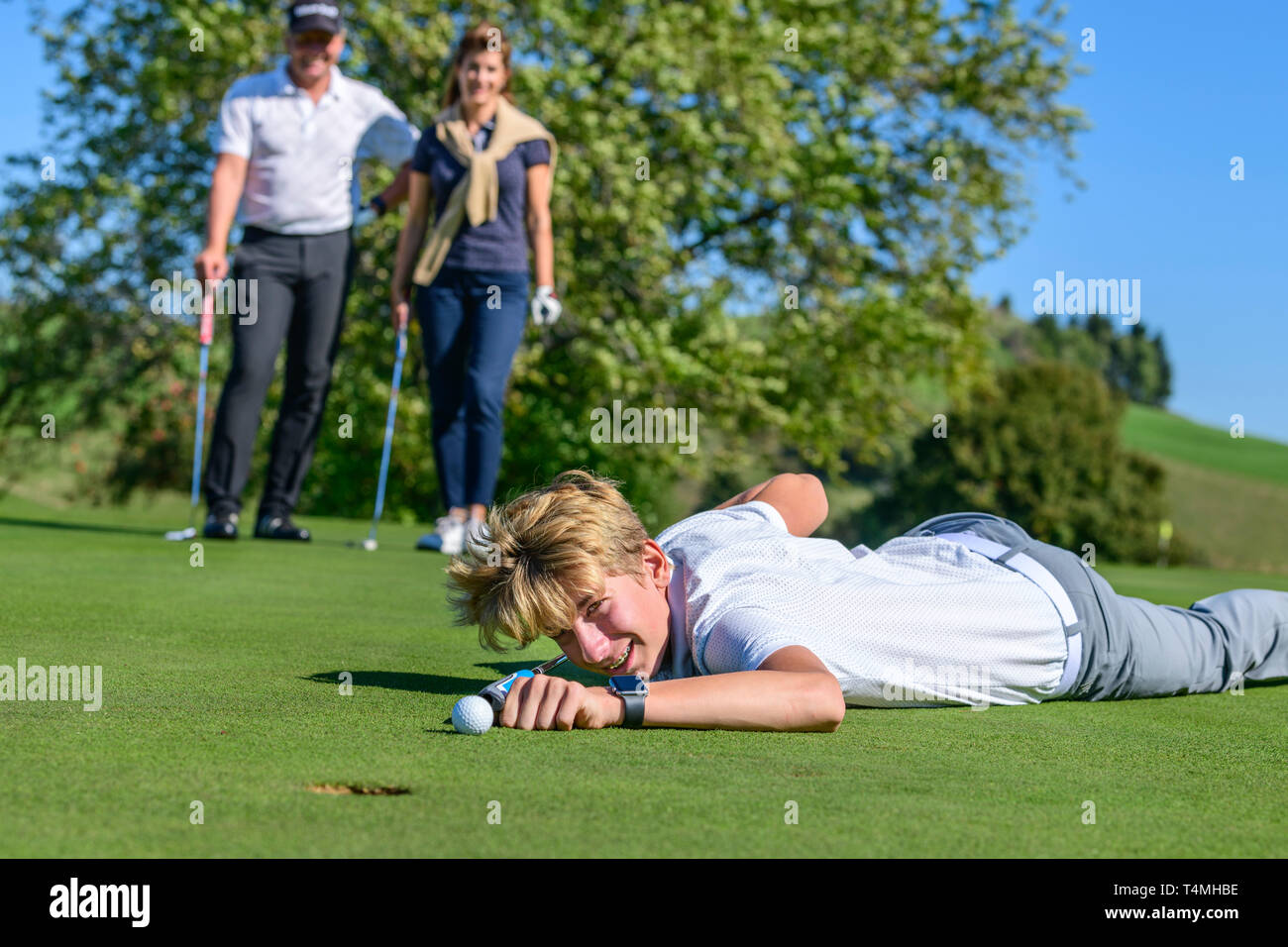Unconventional putting - young golfer putting ball like a billiard player Stock Photo