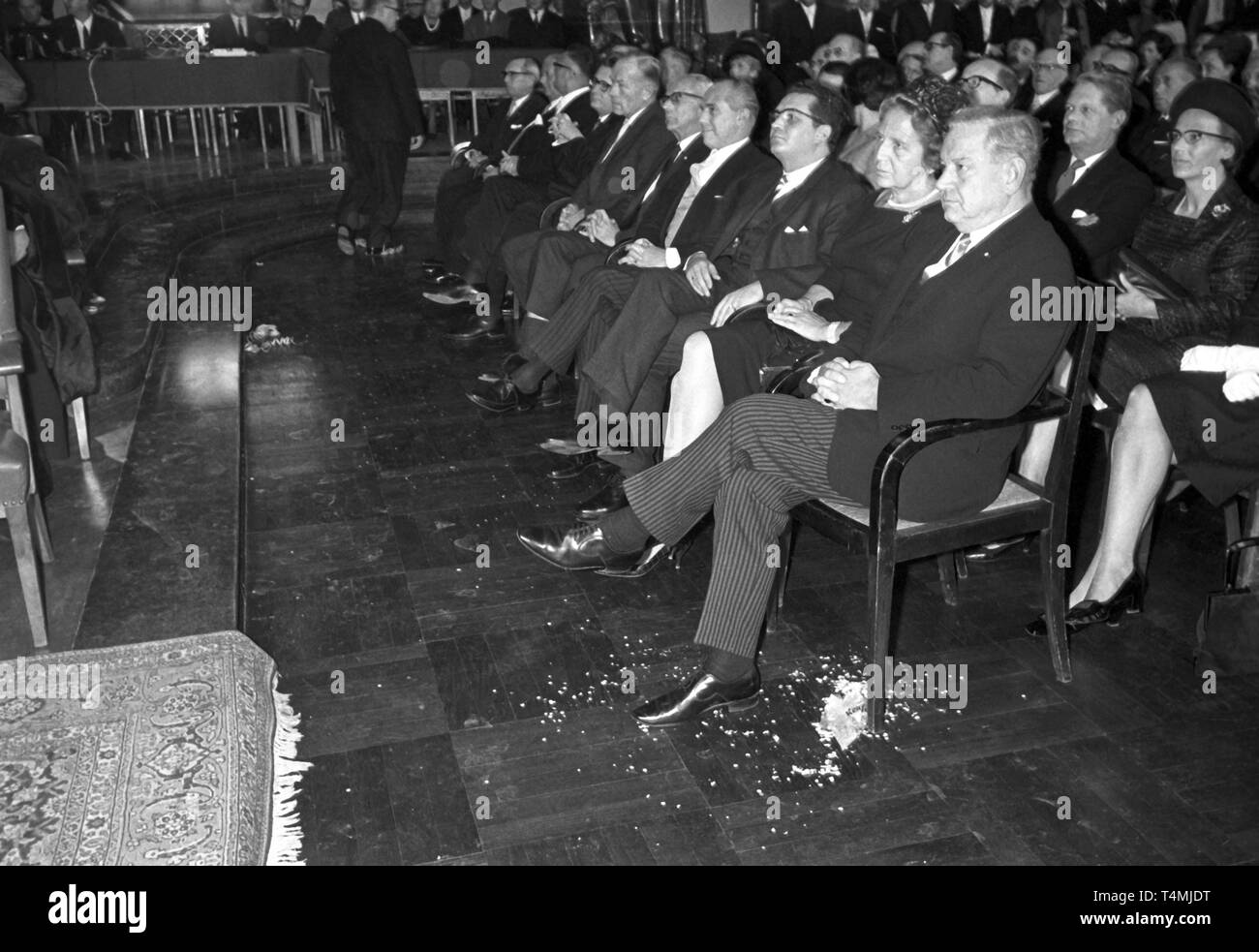 Students disturb the rectorship ceremony on 25 November 1967 in the Auditorium Maximum of Munich University by throwing confetti onto the honorary guests (front row, from right) minister president of Bavaria Alfons Goppel, his wife Gertrud Goppel and Bavarian minister of education Ludwig Huber. | usage worldwide Stock Photo