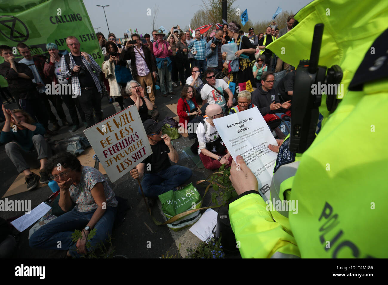A police officer issues a section 14 Public Order Act to Extinction Rebellion demonstrators on Waterloo Bridge, London. Stock Photo