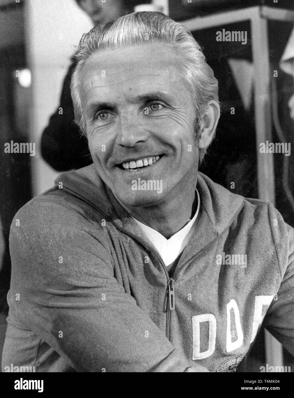 East German soccer coach Buschner smiles while he attends a press conference during the
