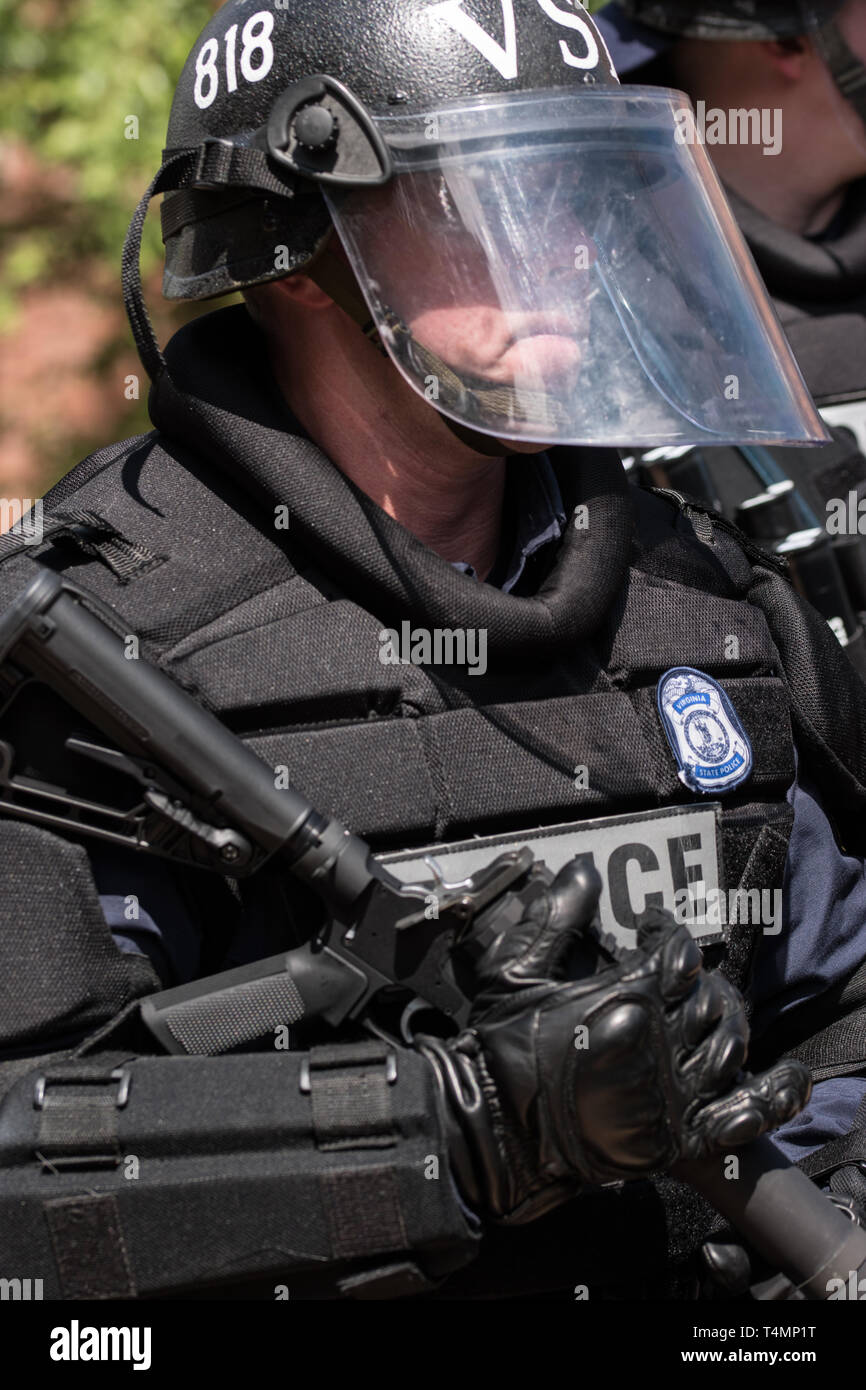 Police in Riot Gear with rifle at KKK Rally in Public Park Stock Photo