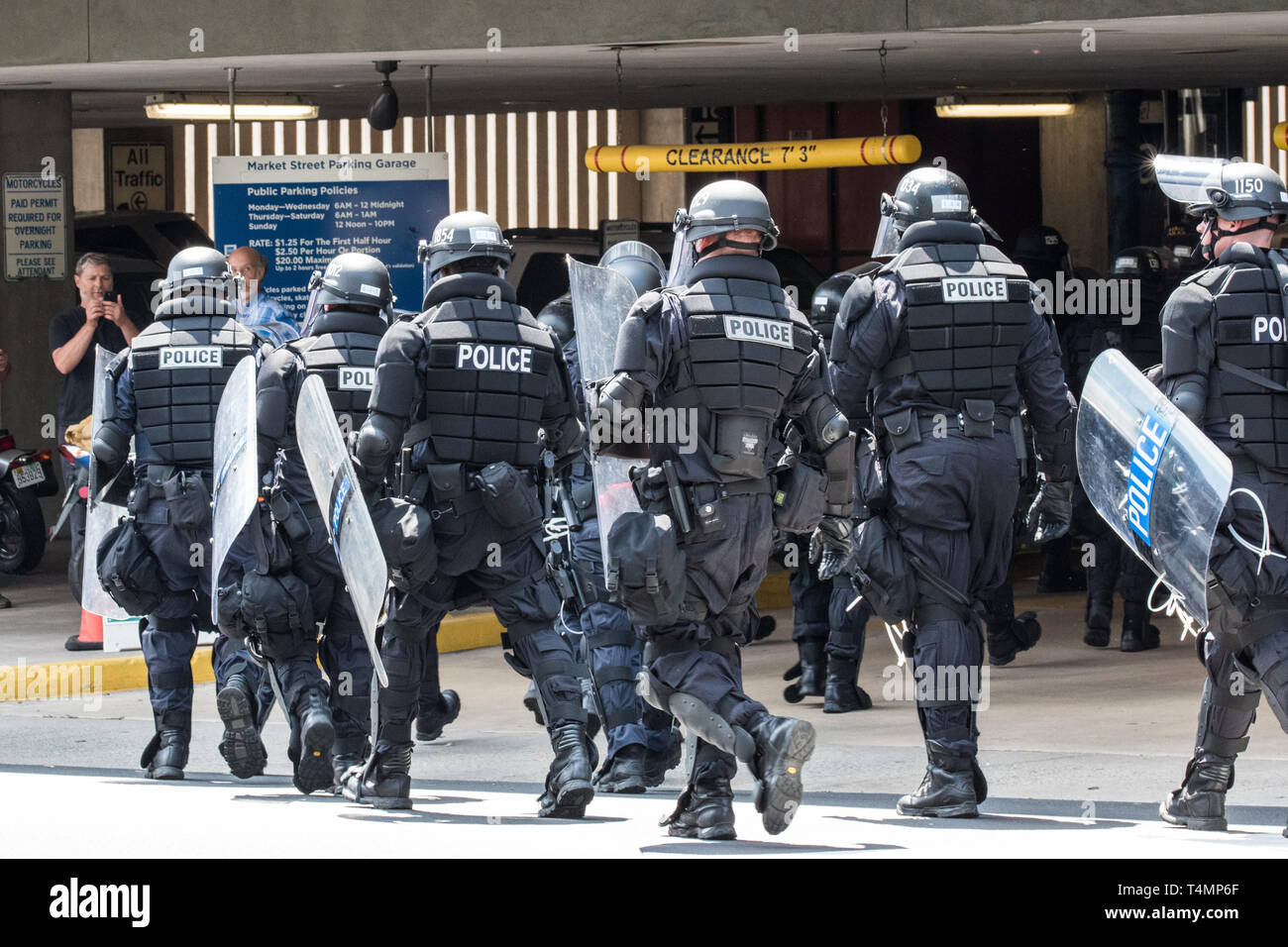 Police in Riot Gear March into Urban Street Garage to Secure Violence Stock Photo