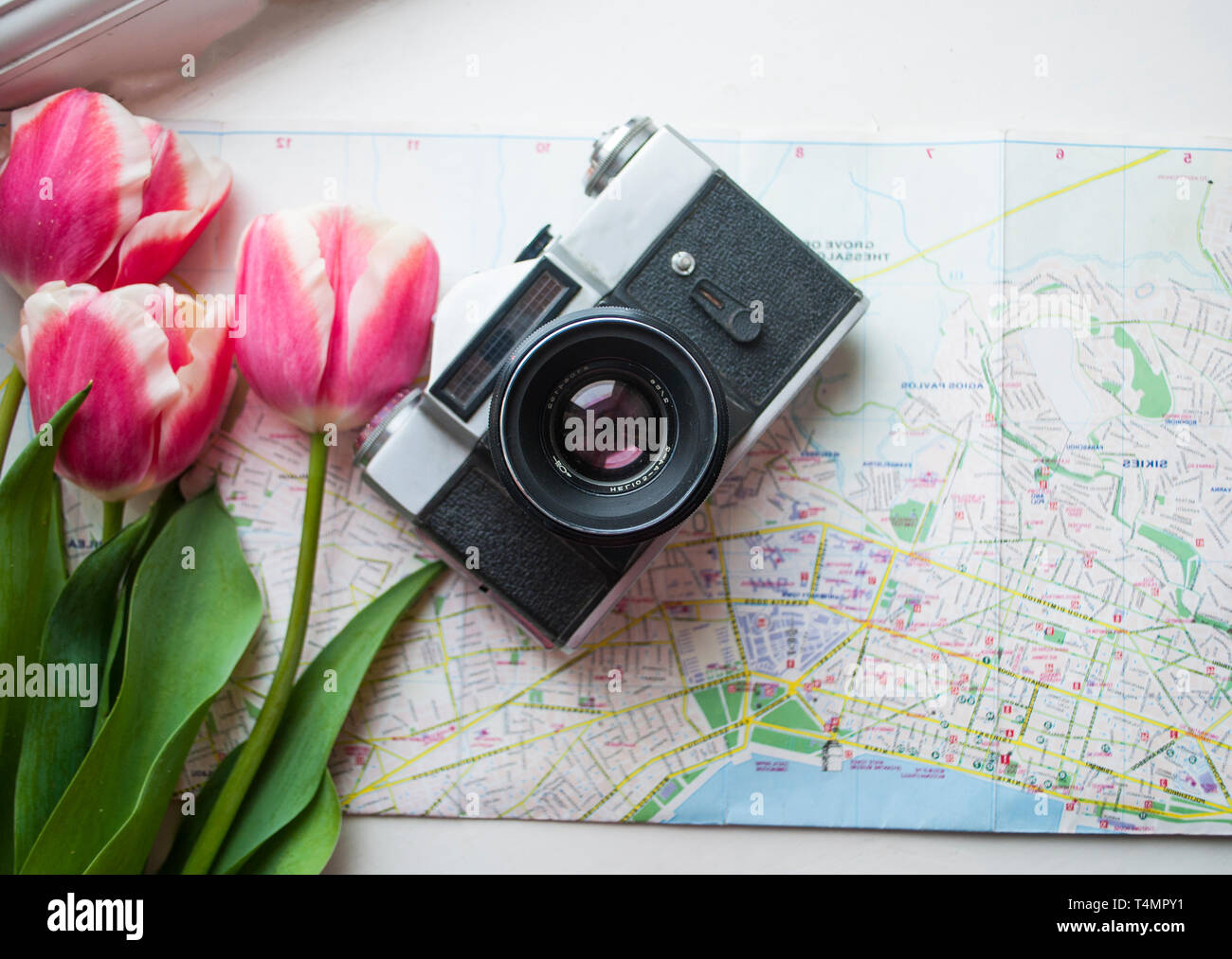 Flat lay of notepad, sun glasses, camera and tulips boquet. Travel concept. Stock Photo