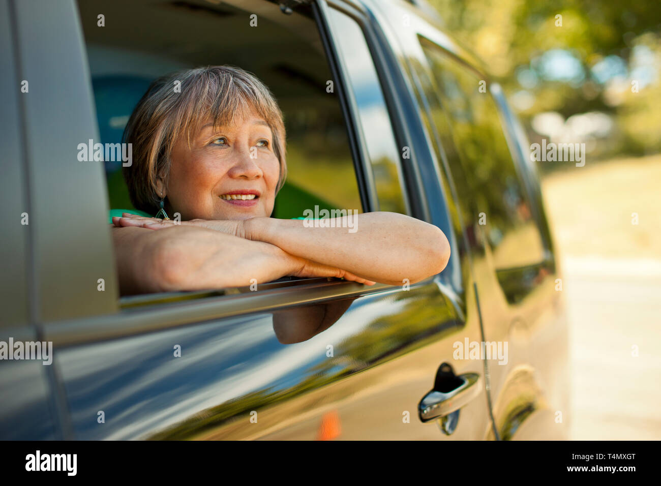Happy senior woman looking out the window of a SUV Stock Photo - Alamy