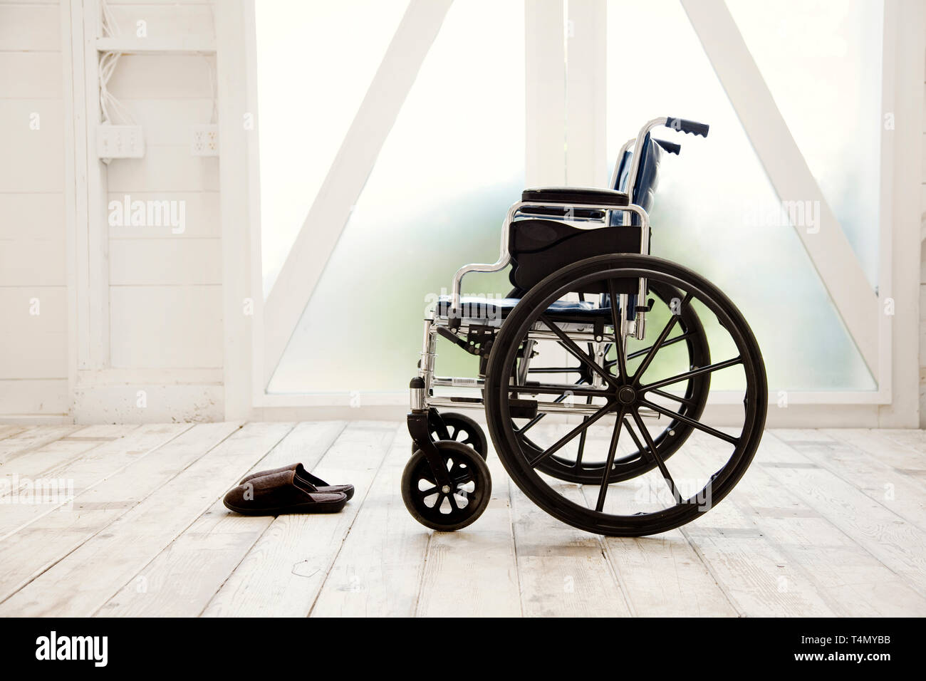 Wheelchair next to a pair of slippers. Stock Photo