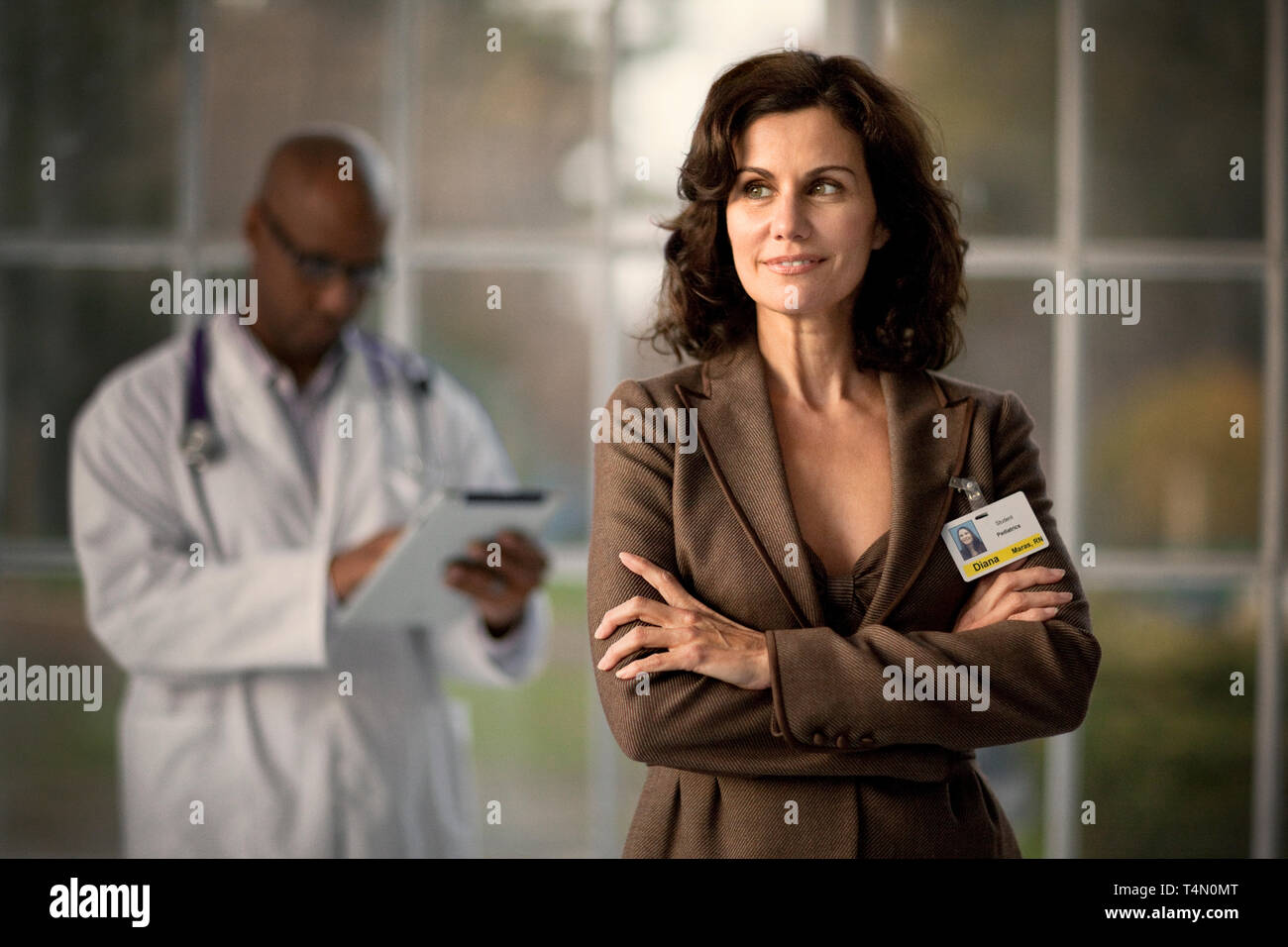 Smiling mid-adult female doctor with her arms crossed. Stock Photo