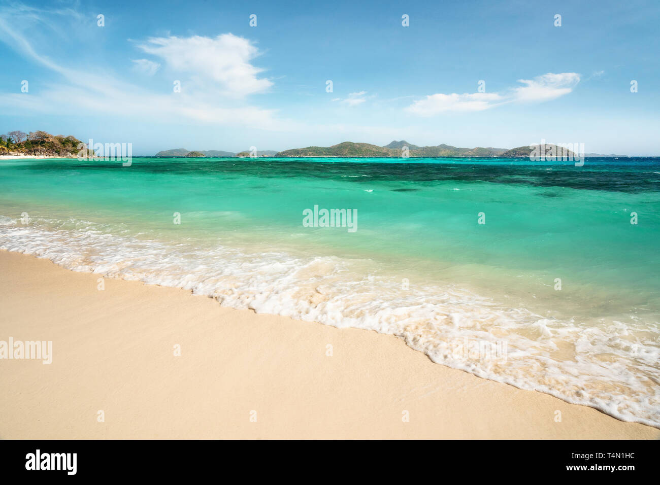 Tropical Malcapuya island with sea foam, azure water and white sand beach. Travel vacation at Philippines. Stock Photo