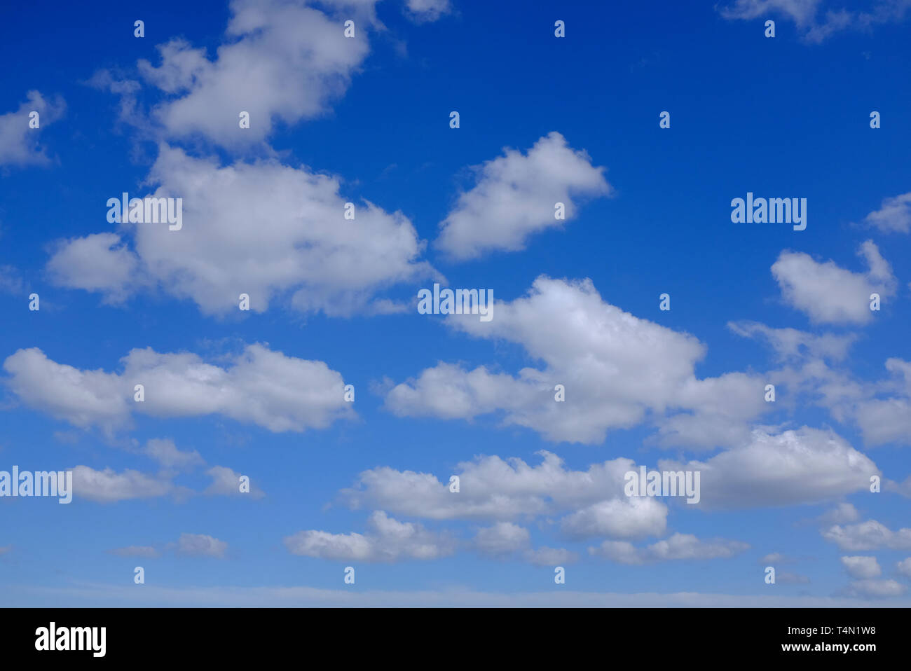 white puffy clouds on bright blue sky background, norfolk, england Stock Photo
