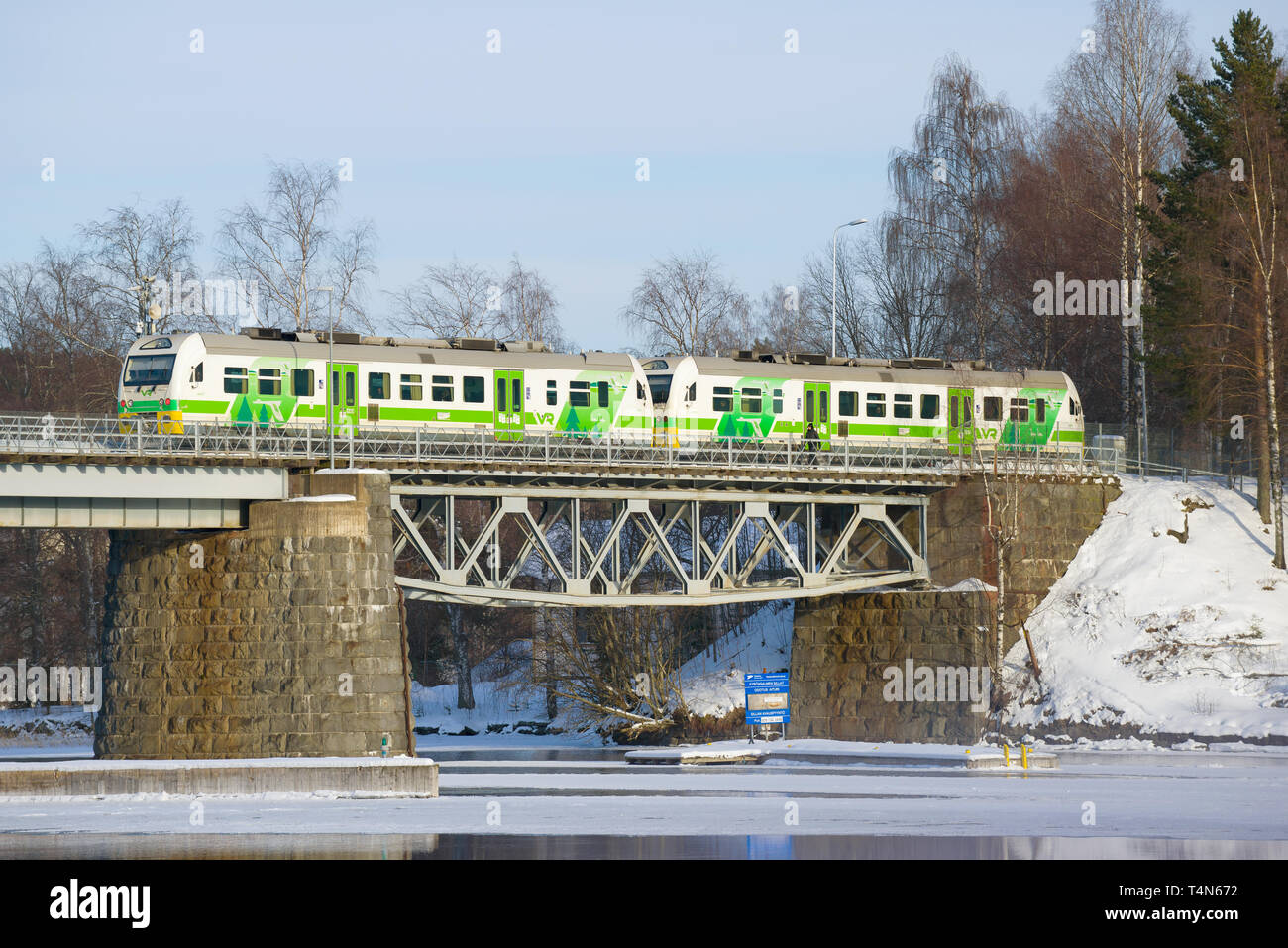 SAVONLINNA, FINLAND - MARCH 03, 2018: The local train on the railway bridge in the sunny March afternoon Stock Photo