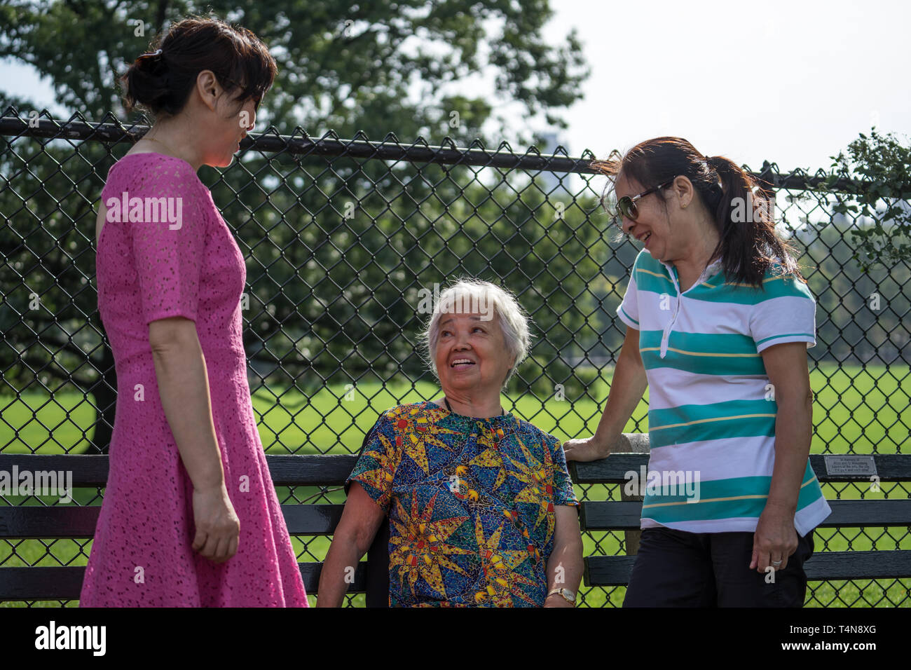 Conversation in the park with a senior asian woman Stock Photo
