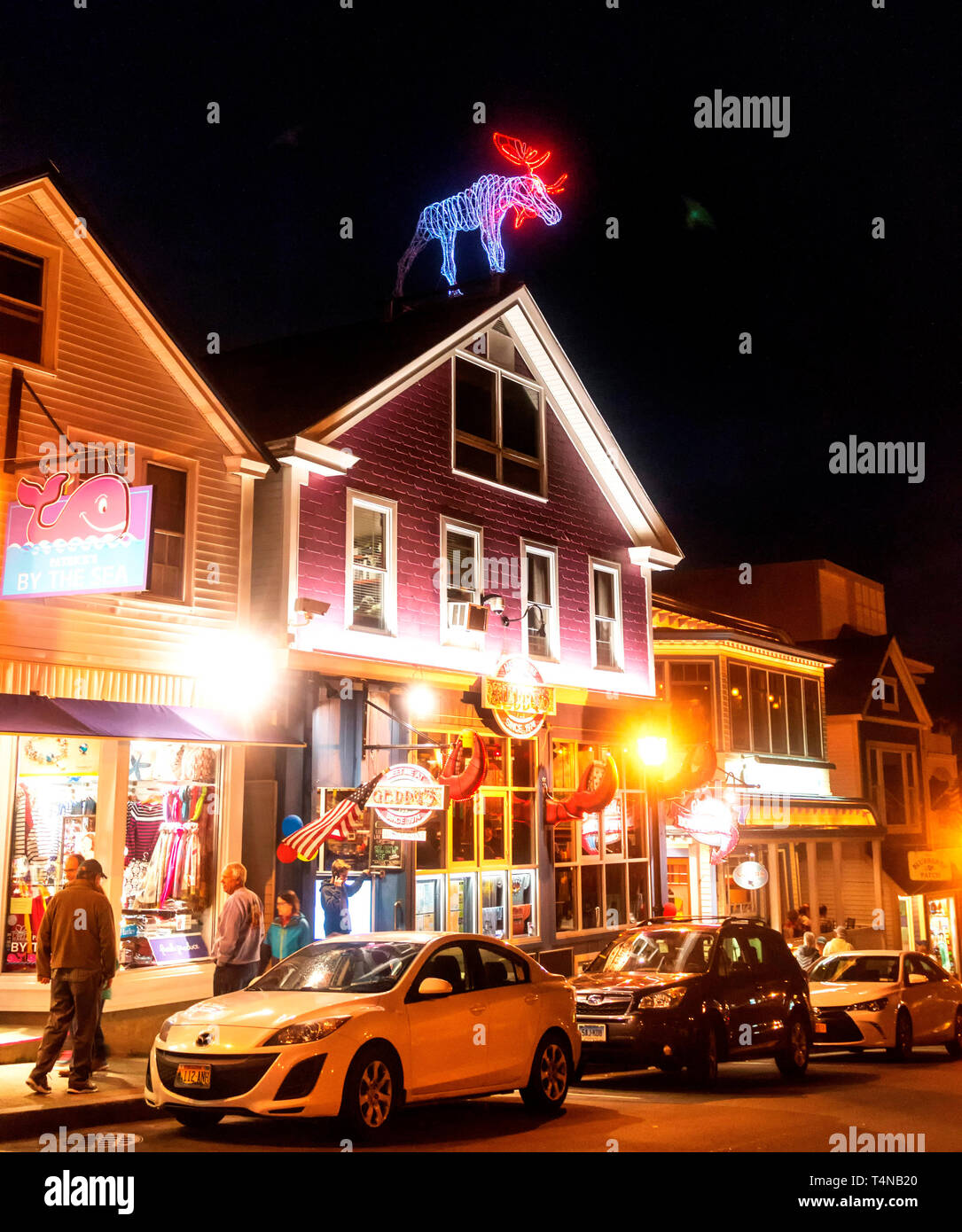 Bar Harbor, Maine, USA – 27 July 2017: View of a very active and bright main street at night with tourists walking the street shopping for souvenirs a Stock Photo