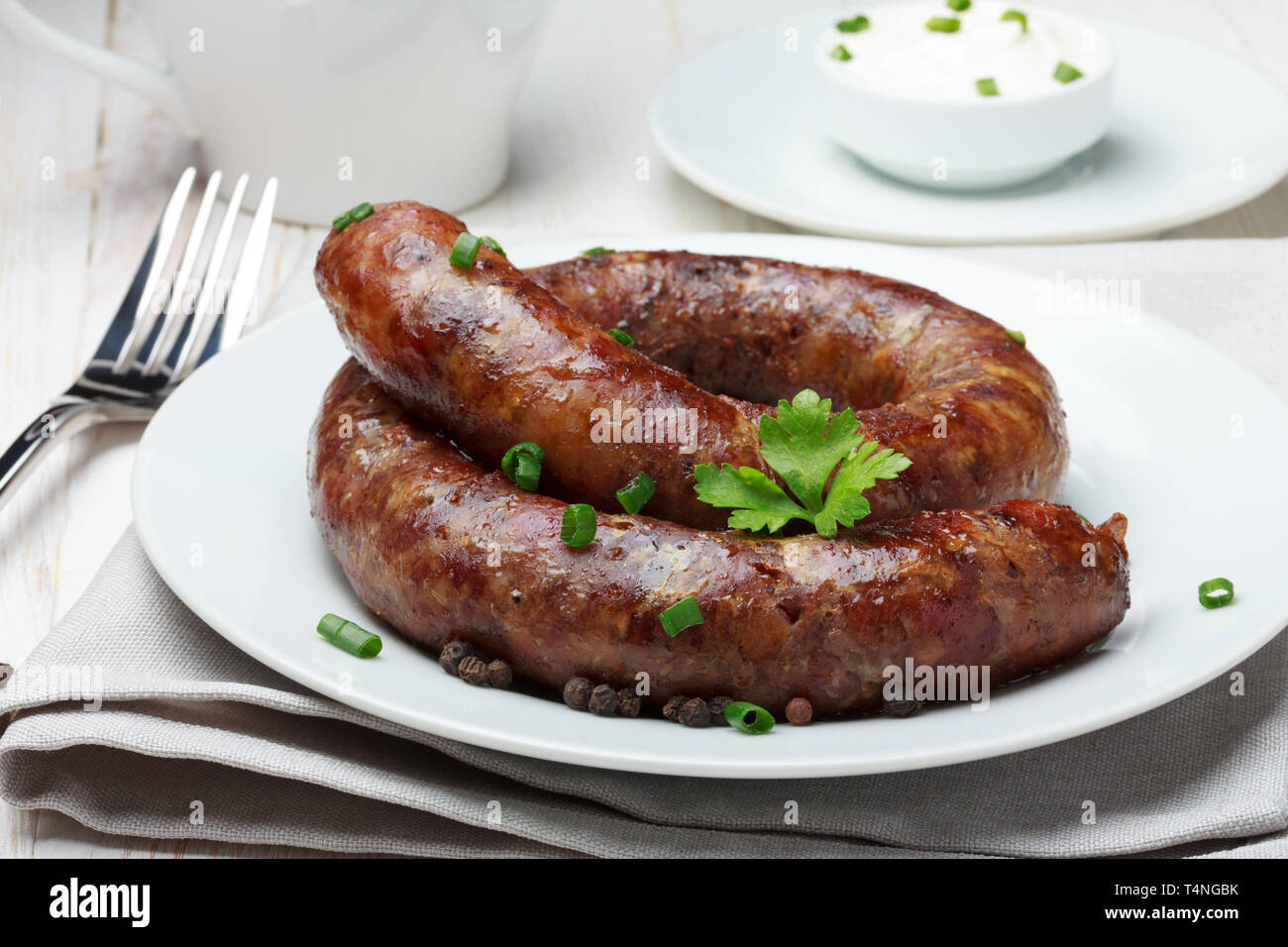 Traditional homemade coiled sausage on wooden table Stock Photo