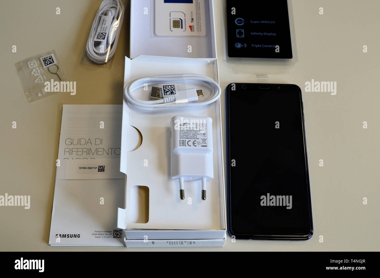 Turin, Piedmont, Italy. April 2019. The package of a Samsung Galaxy A7 has been opened, the smartphone and the accessories are visible: charger, earph Stock Photo